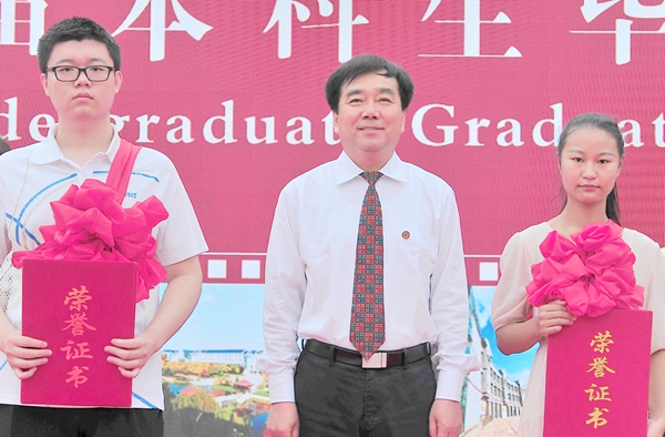 校党委书记李欣章为服务西部计划志愿者王晨曦和赵侃颁发荣誉证书